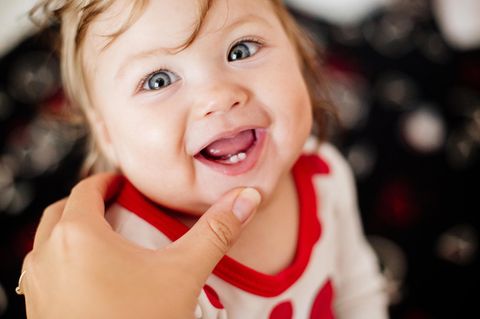 Zahndurchbruch – wie sieht das aus? Lachendes Baby zeigt seine ersten Milchzähne