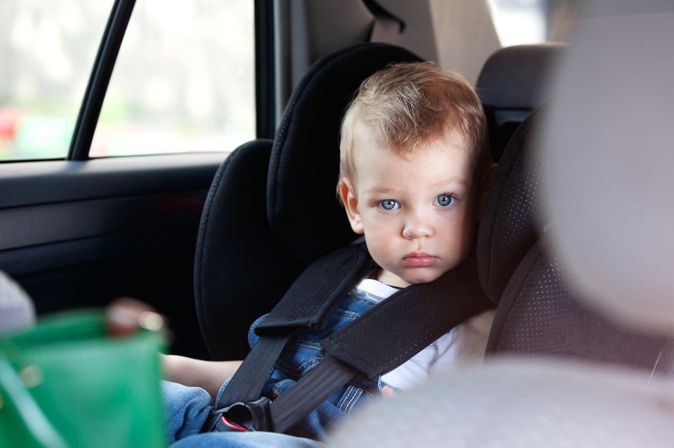 Produktwarnung: Kind in Kindersitz im Auto blickt in die Kamera