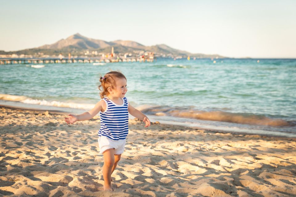Mallorca mit Kindern: Fröhliches Kleinkind an einem Strand auf Mallorca