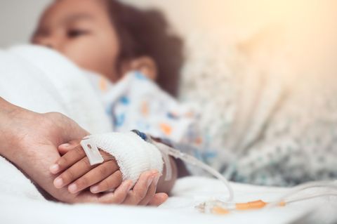 krankes-kind-im-krankenhausbett-hält-hand