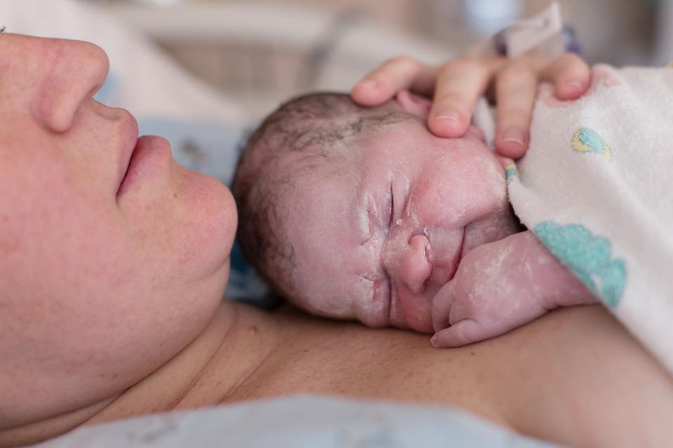 Käseschmiere: Neugeborenes mit Käseschmiere im Gesicht