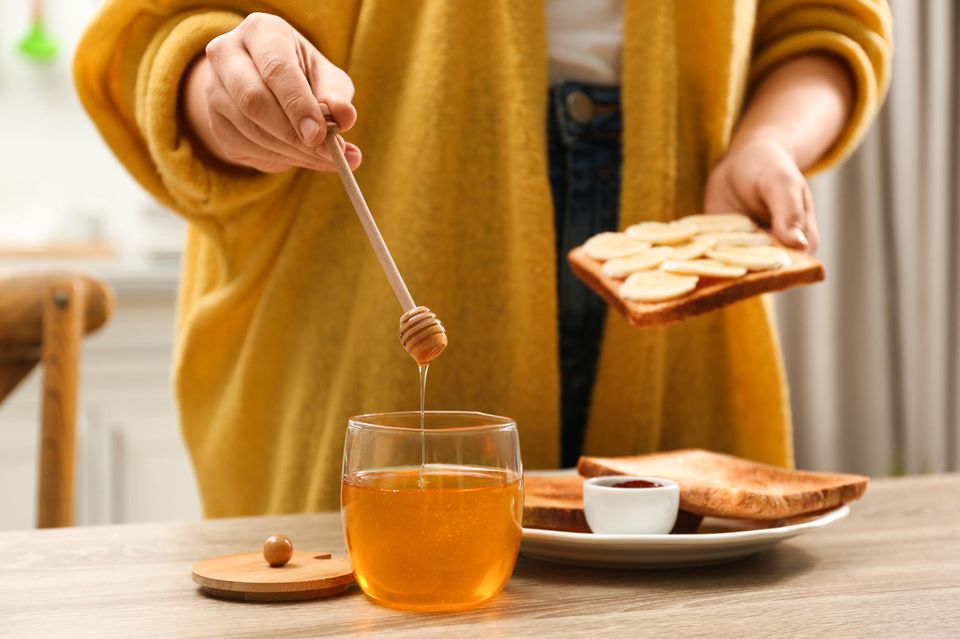 Honig in der Stillzeit: Person bereitet sich ein Toast mit Honig und Bananen zu