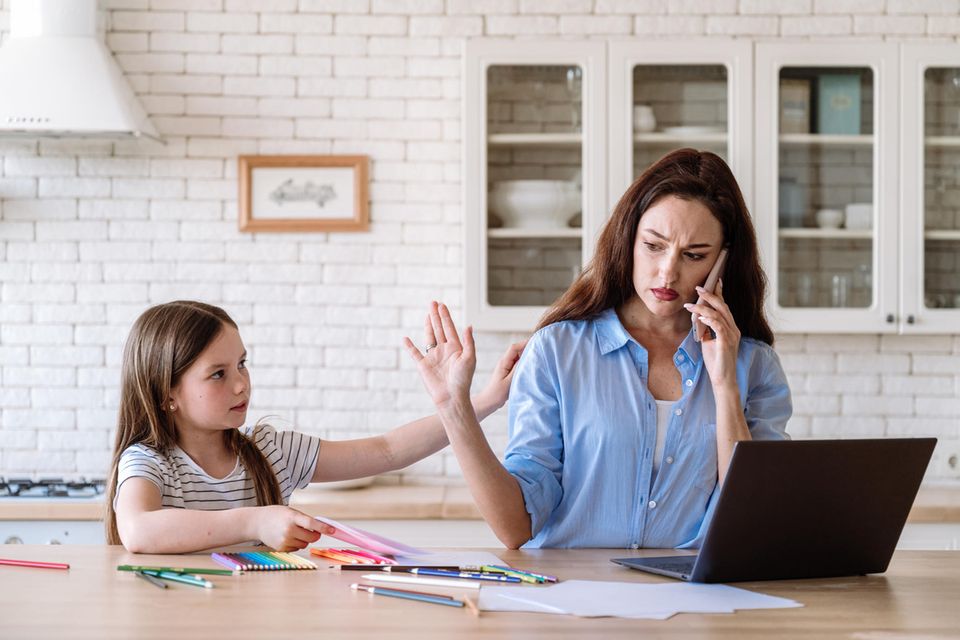 Zeit nehmen: Frau am Telefon weist Kind neben sich ab